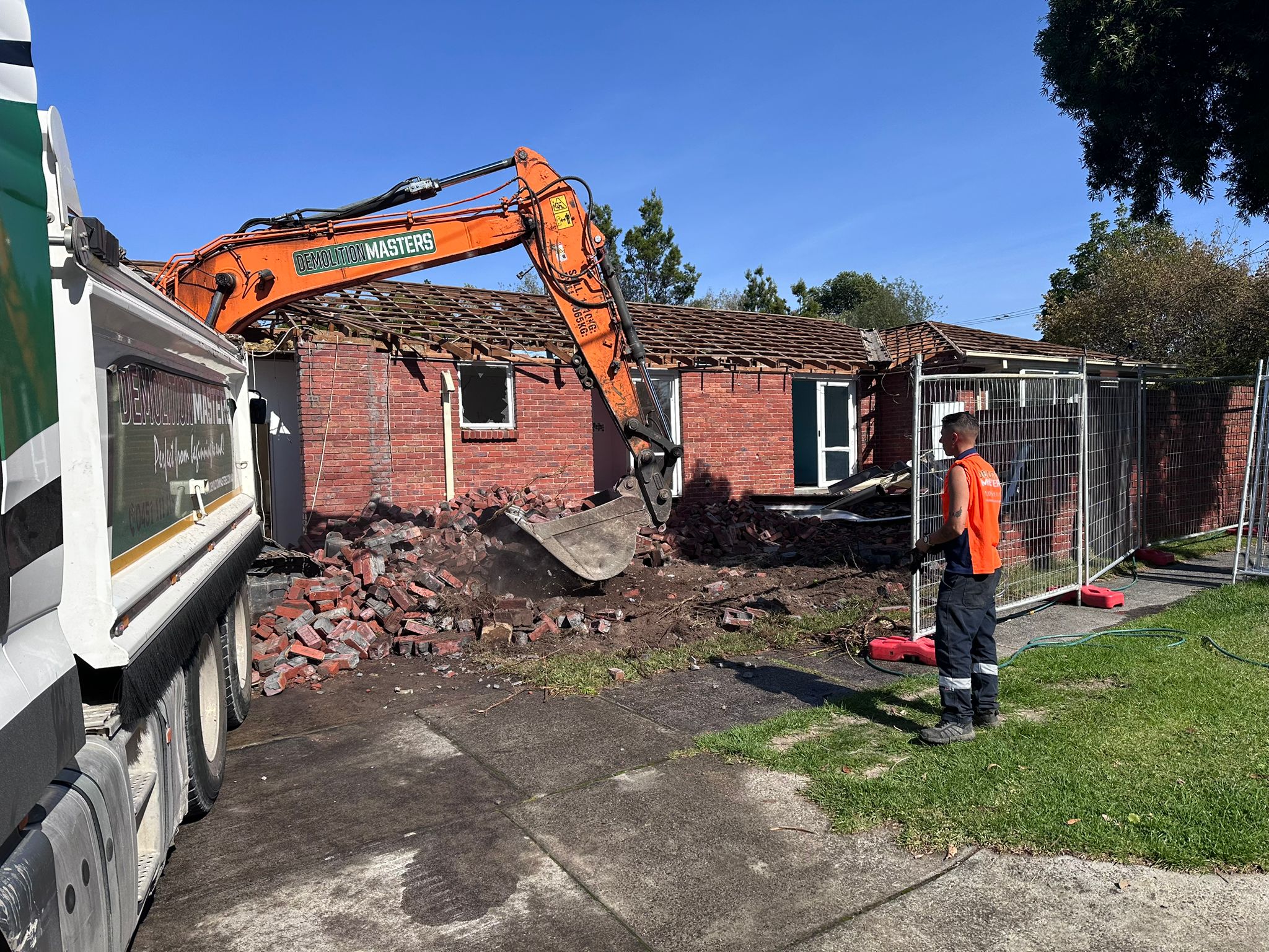 Branded Demolition Masters excavator working on a residential demolition site in Melbourne